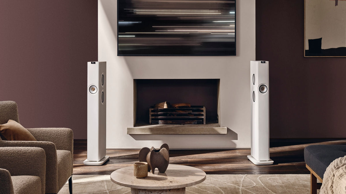 White KEF LS60 Wireless Speaker placed in modern living with a fireplace 